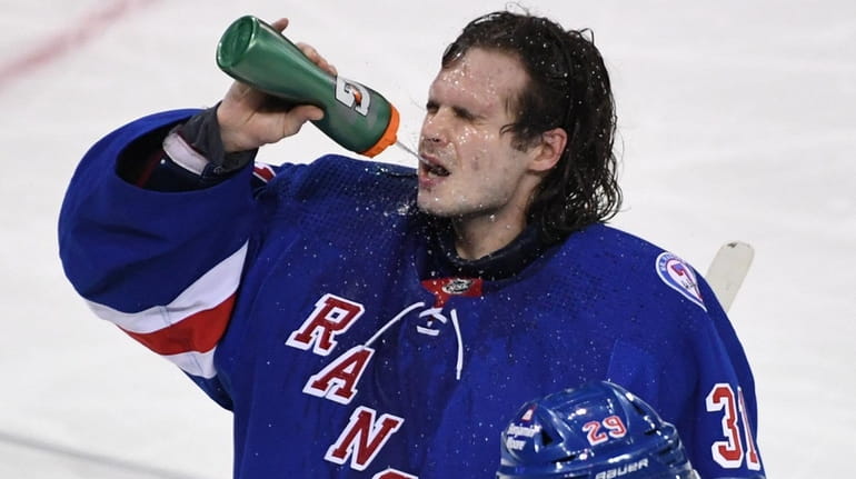 Rangers goaltender Igor Shesterkin hydrates during a break in the...