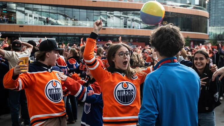 Edmonton Oilers fans react to a goal as they watch...