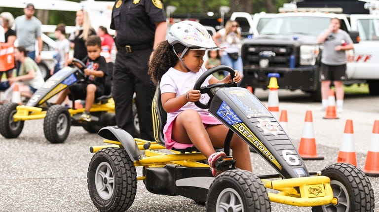 Bella Horne, 5, of Shirley, rides a pedal cart during...