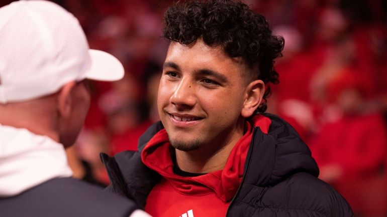 Dylan Raiola chats with supporters courtside before an NCAA college...