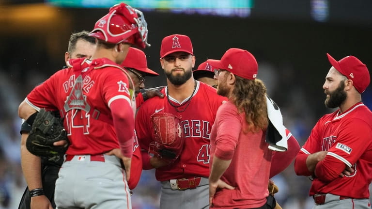 Los Angeles Angels starting pitcher Patrick Sandoval, center, is checked...