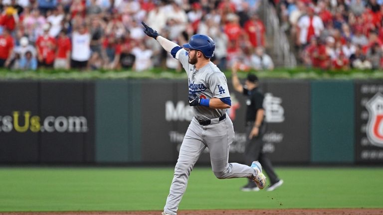 Los Angeles Dodgers' Gavin Lux gestures to teammates after hitting...