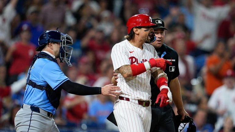 Philadelphia Phillies' Nick Castellanos, center right, reacts after he was...