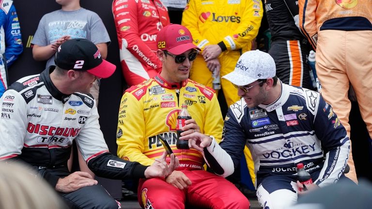 Austin Cendric, left, Joey Logano, center, and Daniel Suarez talk...