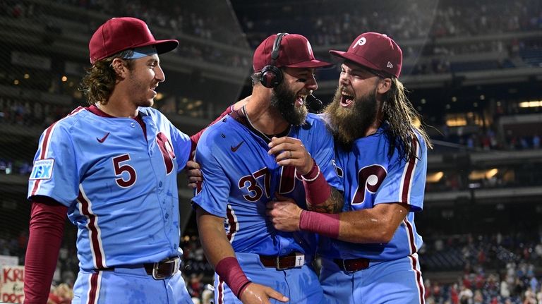 Philadelphia Phillies' Weston Wilson, center, celebrates after he was doused...