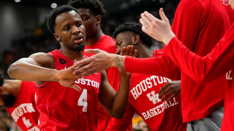 Houston guard L.J. Cryer (4) is greeted at the bench...