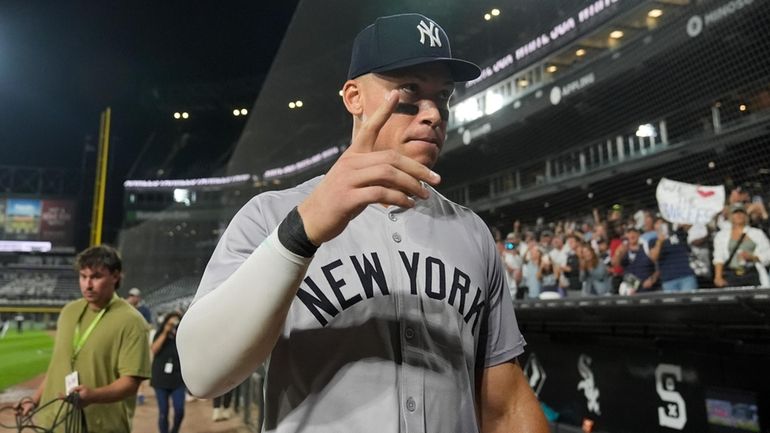 The Yankees' Aaron Judge signals to fans after he hit...