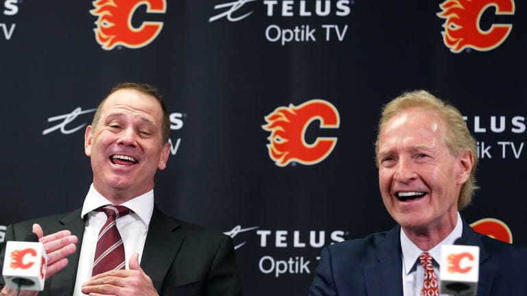 Newly-appointed Calgary Flames general manager Craig Conroy, left, laughs with...