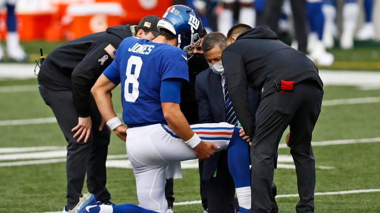Trainers check Giants quarterback Daniel Jones after an injury during...