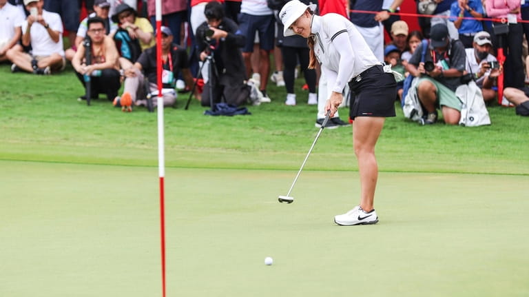 Hannah Green of Australia plays a putt on the 18th...