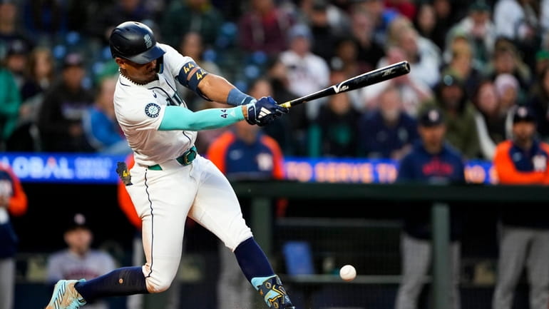 Seattle Mariners' Julio Rodríguez hits an RBI single against the...