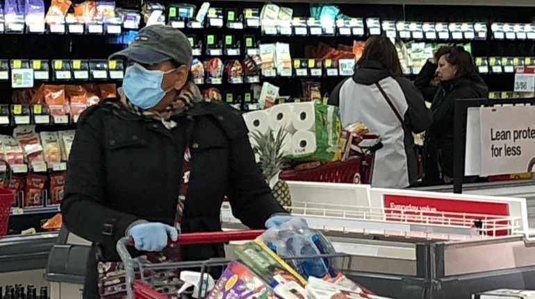 A shopper wears a mask and rubber gloves at Target...