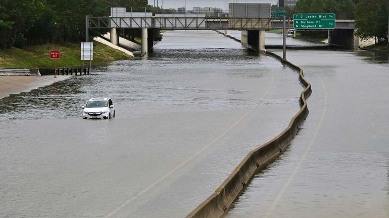 A vehicle is stranded on flooded Interstate 10 after Hurricane...