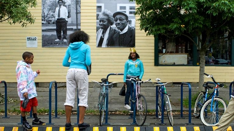 Three "Hello Neighbor" students celebrate the unveiling of their work outside...