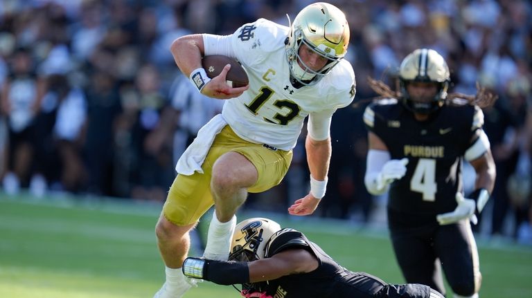 Notre Dame quarterback Riley Leonard (13) goes over Purdue defensive...