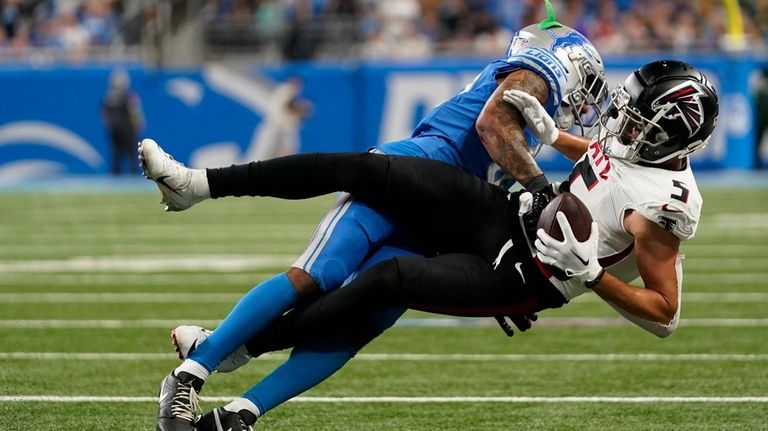 Atlanta Falcons wide receiver Drake London (5) is brought down...