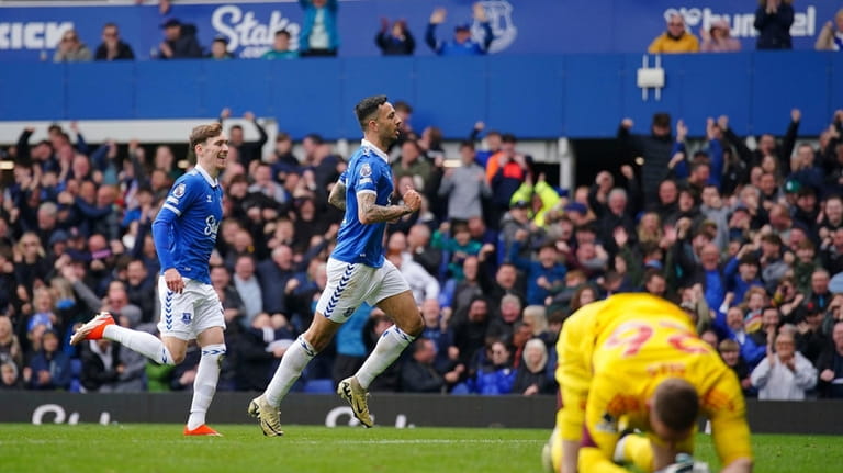 Everton's Dwight McNeil, centre, celebrates scoring their side's second goal...