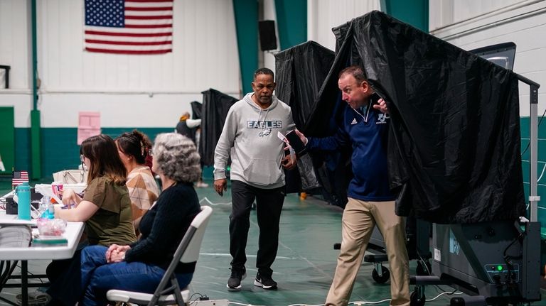 Voters step from booths after casting their ballots on election...