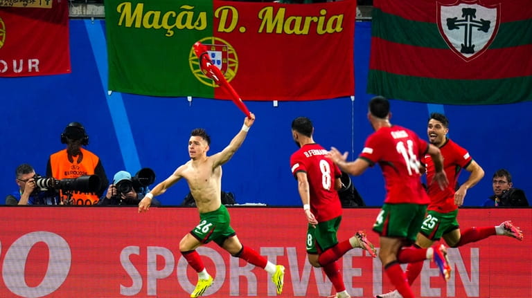 Portugal's Francisco Conceicao, left, celebrates with teammates after scoring his...