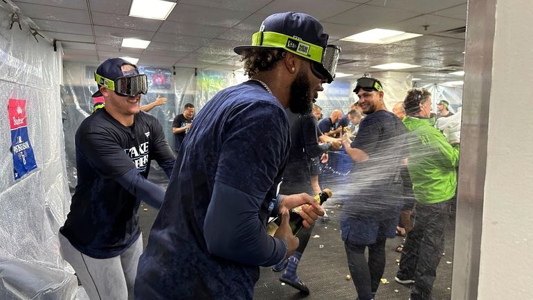 Tampa Bay Rays shortstop Junior Caminero, center, celebrates with teammates...