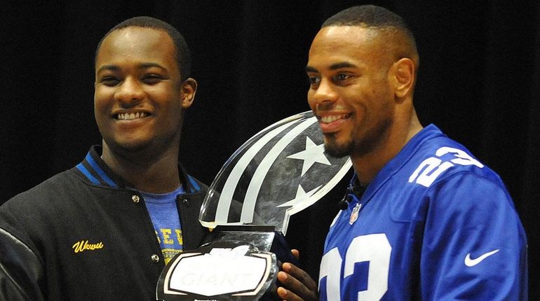 Roosevelt High senior Chukwuma Ukwu, left, gets presented with the...