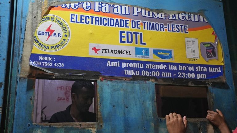 A man sells electricity credit at a shop in Dili,...