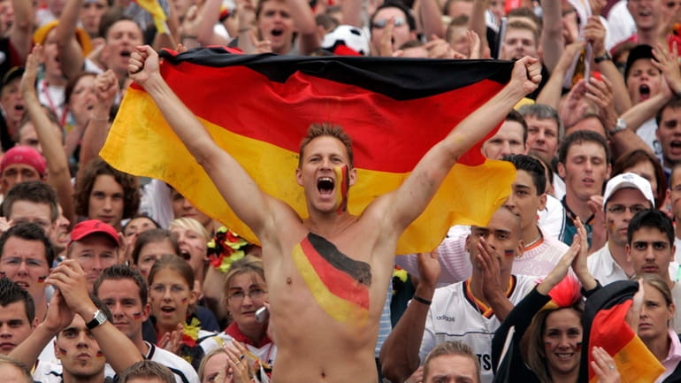 German soccer fans celebrate while watching the World Cup quarterfinal...