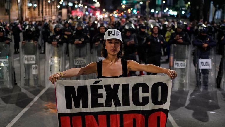 Student Daniela Camberos shows a banner in front of the...