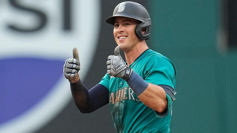 Seattle Mariners' Dylan Moore gestures at second base after hitting...