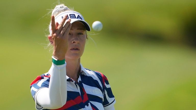 Nelly Korda, of the United States, throws her ball to...