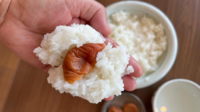 Umeboshi is put on cocked rice in Tokyo, on June...