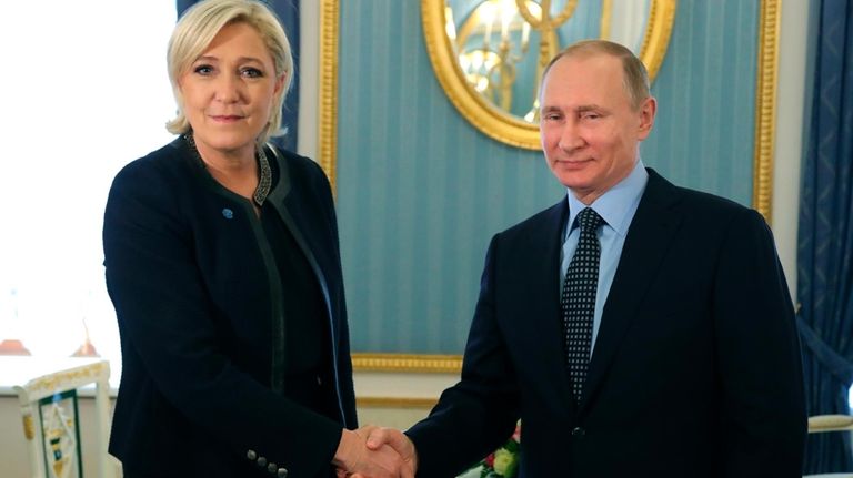 Russian President Vladimir Putin, right, shakes hands with French far-right...