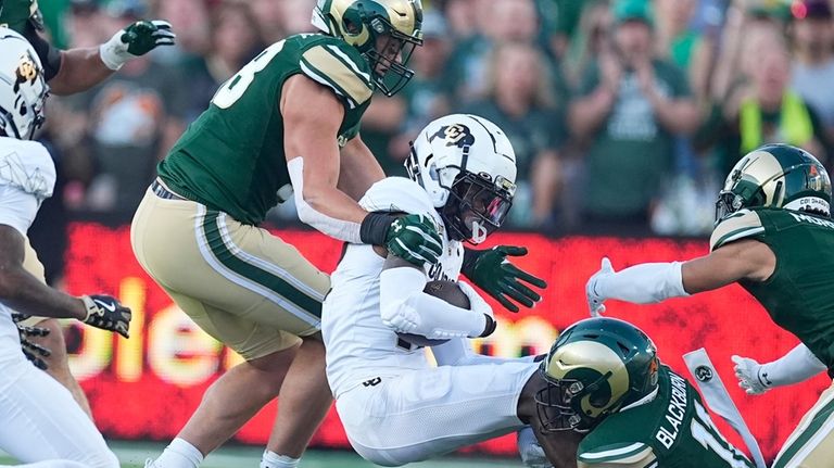 Colorado wide receiver Travis Hunter, second from left, is stopped...