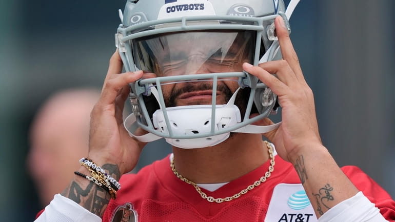 Dallas Cowboys quarterback Dak Prescott puts on his helmet before...