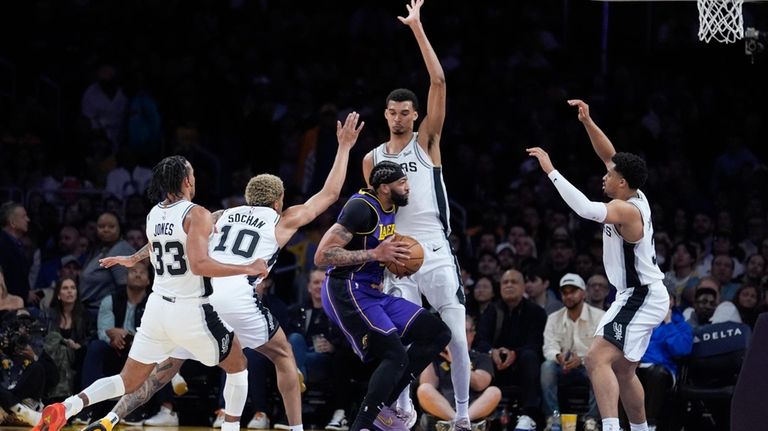 Los Angeles Lakers forward Anthony Davis, center, drives to the...