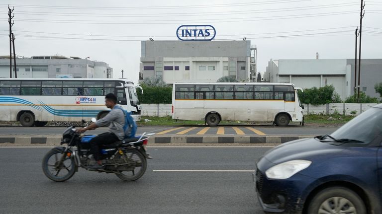 Commuters drive past the INTAS pharmaceutical manufacturing plant in Ahmedabad,...