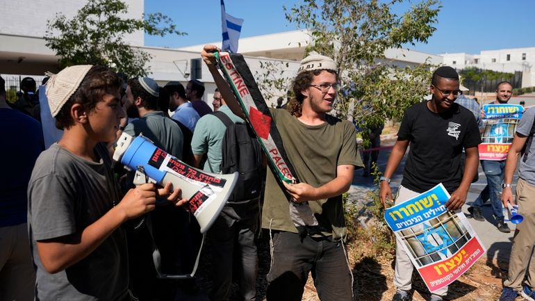 Right-wing Israelis, one holding a Palestinian scarf, at a protest...