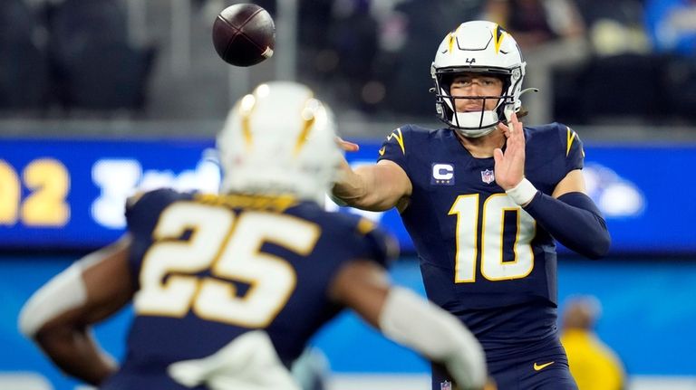 Los Angeles Chargers quarterback Justin Herbert (10) throws to running...