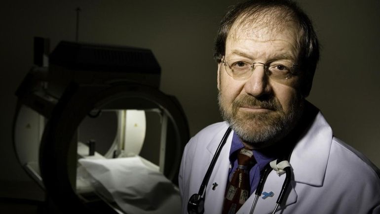 Dr. E. Roy Berger, pictured in front of a bone...