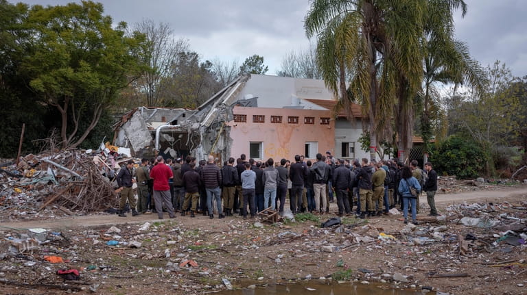 A group of Israelis visit a damaged house following the...