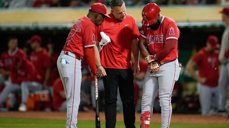 Los Angeles Angels' Luis Rengifo, right, talks holds his arm...