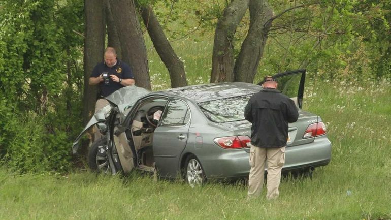 Police investigate the scene of a fatal, single-car crash on...