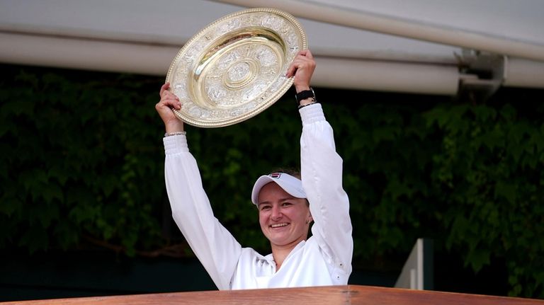 Barbora Krejcikova of the Czech Republic holds up the winners...