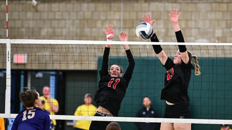 Mineola’s Elizabeth Kenney, left, and Keira McCaffrey attempt to block...