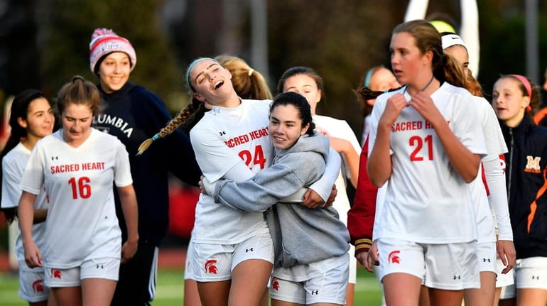 The Sacred Heart girls soccer team celebrates its victory over...