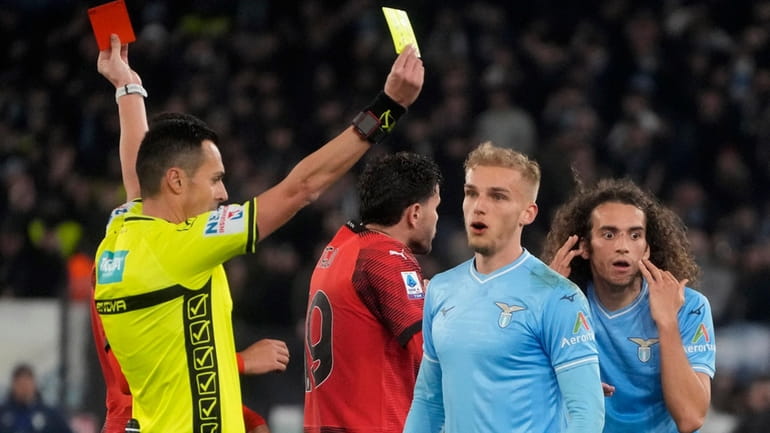 Referee Marco di Bello shows the red card to Lazio's...