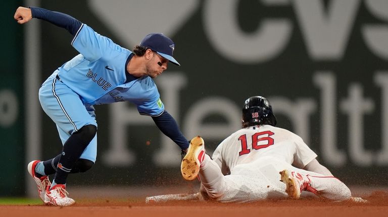 Toronto Blue Jays shortstop Ernie Clement, left, tags out Boston...