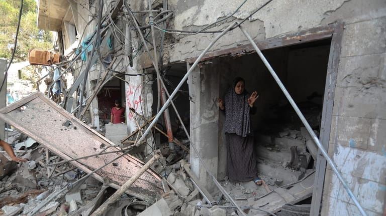 Palestinians inspect the damage of buildings that were hit by...