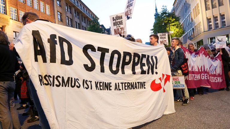 Participants in a demonstration against the right hold a banner...