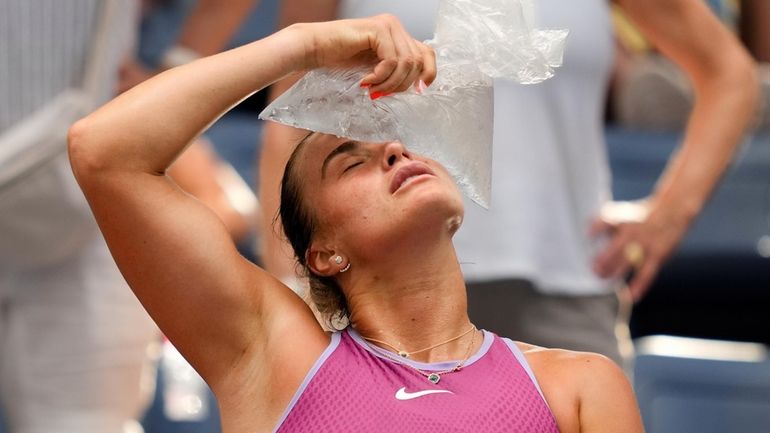 Aryna Sabalenka cools off with a bag of ice between games...